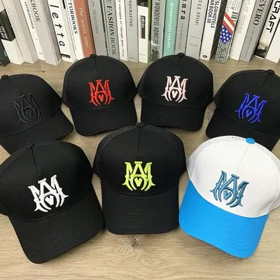 Six embroidered baseball caps in black, orange and two-tone colourways